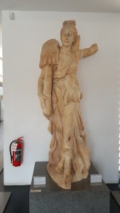 Zafer tanrıçası nike. Tiyatro'da bulunmuştur. M.Ö. 1. yy. Antik Çağ'da tiyatroda sahneyi süsleyen heykellerden biri olan bu eser kanatlı tanrıça, sağ elinde tuttuğu üst kısmı zırh süslemeli bir zafer direği ile birlikte gökyüzünden aşağı doğru inmektedir. Afrodisias'da üretilen en erken mermer yontulardan biridir. Nike (Goddess of Victory). Scene building of Theater. Late 1st century BC. The statue decorated the stage-building of tehater. It represent Nike (Victory) landing on the building, holding a trophy. This is one of the earliest marble statues made at Aphrodisias.